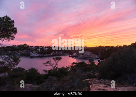 Anzeigen eines farbenfrohen Sonnenuntergang über Cala Llombards auf Mallorca, Spanien. Stockfoto