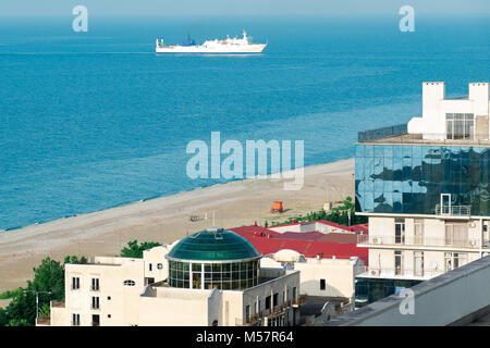 Ansicht von oben Stadt mit schönen Häuser am Meer mit schwimmenden weißen Schiff. Stadt Leben am Meer. Reisen und Ferien Hintergrund. Stockfoto