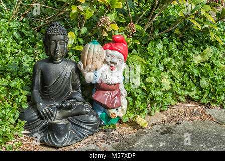 Buddha und Gnome gepflastert, in einem Garten Stockfoto