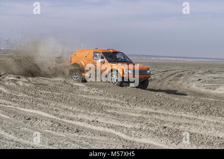 Orange Rennwagen am Strand mit voller Geschwindigkeit Stockfoto