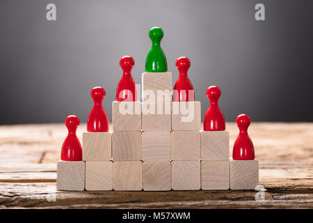 Nahaufnahme von grünen und roten Spielball Figürchen auf Holzblöcken angeordnet Stockfoto