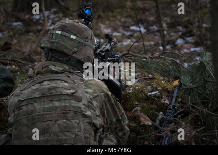 Ein US-Soldat zu Bügeleisen Truppe, 3 Staffel, 2 Cavalry Regiment zugeordnet, zieht Sicherheit während in der multinationale Übung Puma die Teilnahme an einer Reihe in der Nähe der Bemowo Piskie, Polen, 19.02.2018. Diese Soldaten sind Teil der einzigartigen, multinationalen Battle Group aus USA, Großbritannien, Kroatischen und rumänischen Soldaten, die mit der polnischen 15 mechanisierte Brigade als Abschreckung Kraft im Nordosten Polens zur Unterstützung des NATO-Enhanced vorwärts Präsenz dienen. (U.S. Armee Foto von SPC. Andrew McNeil/22 Mobile Public Affairs Abteilung) Stockfoto