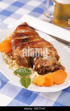 Eisbein, gebratene Schweinshaxe mit geschmortem Weißkohl und Bier Stockfoto