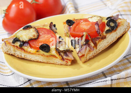 Pizza mit Kürbis, Tomaten, Oliven, Zwiebeln und Käse Stockfoto