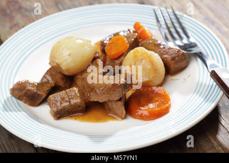 Beef Bourguignon in eine Platte auf einem rustikalen Tisch Stockfoto