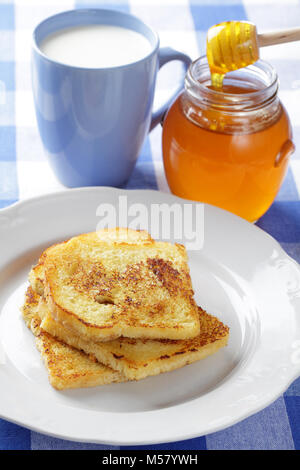 French Toast, Krug Honig und eine Tasse Milch Stockfoto