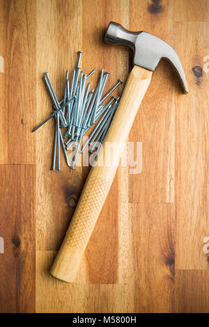 Hammer und Nägel auf Holztisch. Stockfoto