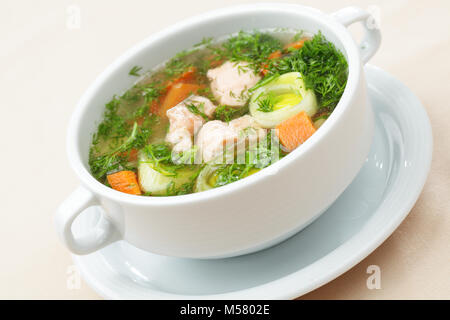 Suppe mit Lachs und Gemüse in einer weißen Schüssel Stockfoto