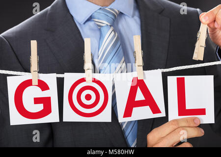 Closeup Mittelteil des Geschäftsmannes pinning Ziel Karten auf wäscheleine Stockfoto