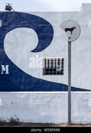 Gebleicht" keine Hunde' Zeichen vor einer Wand mit einer vergitterten Fenster und eine lackierte Blue Wave in Corralejo, Fuerteventura, Spanien, Europa, Afrika. Stockfoto