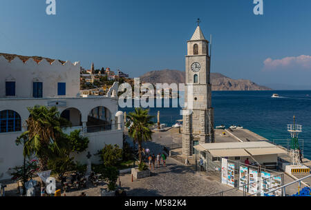 Der Uhrturm und die Einfahrt in den Hafen von Symi (Simi), eine kleine Insel der Dodekanes in Griechenland. Stockfoto