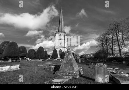 Kirchhof der St. Mary's Kirche, Painswick, einer unberührten Dorf in der Grafschaft Gloucestershire Cotswolds, mit pyramidenförmigen Grab von Steinmetz John Bryan Stockfoto