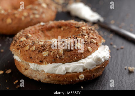 Sandwich Bagel mit Frischkäse auf einer Schiefertafel Schneidebrett Stockfoto