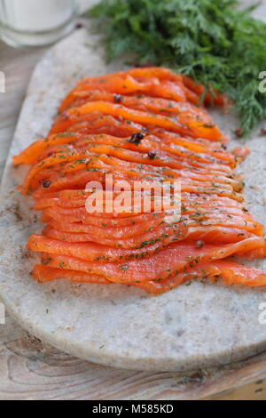 In Scheiben geschnitten gesalzen Lachsfilet auf einem Schneidebrett Stockfoto