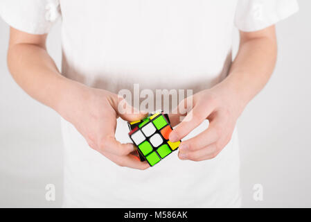 Teenager Geschwindigkeit Lösung 3 x 3 Würfel Puzzle im weißen T-Shirt mit weissem Hintergrund Stockfoto