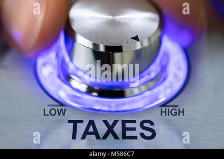 Nahaufnahme von Hand drehen beleuchtete metallische Knopf durch Steuern text Stockfoto