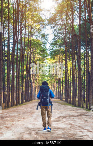 Wandern Mann mit Rucksack zu Fuß in den Wald. Stockfoto
