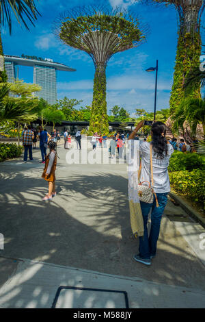 Singapur, Singapur - Januar 30, 2018: Nicht identifizierte Frau, die Bilder von supertree an Gärten an der Bucht. Die baumartige Strukturen werden mit Umwelttechnologien, dass die ökologische Funktion der Bäume nachahmen ausgestattet Stockfoto