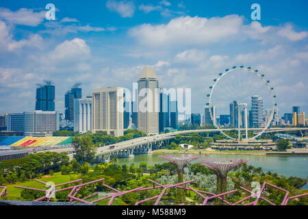 Singapur, Singapur - Februar 01, 2018: Im freien Blick auf den Singapore Flyer - das größte Riesenrad der Welt, mit einer Brücke und einem riesigen Gebäuden in den Horizont, in Singapur. Stockfoto