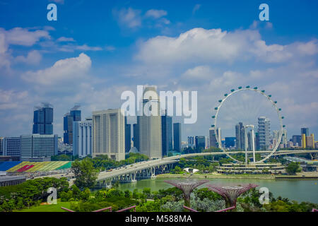 Singapur, Singapur - Februar 01, 2018: Im freien Blick auf den Singapore Flyer - das größte Riesenrad der Welt, mit einer Brücke und einem riesigen Gebäuden in den Horizont, in Singapur. Stockfoto