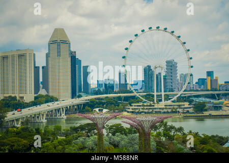 Singapur, Singapur - Februar 01, 2018: Die Schöne im Blick auf Singapur Flyer - das größte Riesenrad der Welt, mit einer Brücke und einem riesigen Gebäuden in den Horizont, in Singapur. Stockfoto