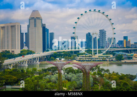 Singapur, Singapur - Februar 01, 2018: Die Schöne im Blick auf Singapur Flyer - das größte Riesenrad der Welt, mit einer Brücke und einem riesigen Gebäuden in den Horizont, in Singapur. Stockfoto