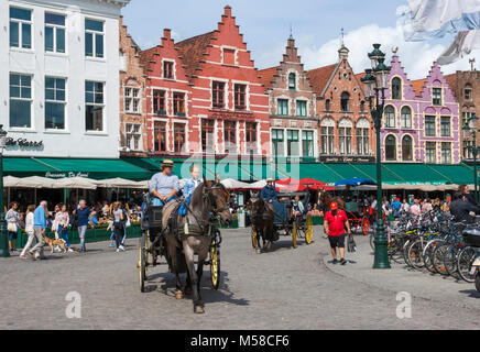 Pferdekutsche in der Grote Markt (Marktplatz), Touristen, die auf kurzen Besichtigungstouren. Brügge, Belgien. Stockfoto
