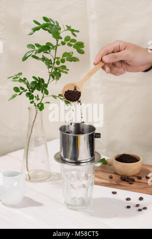 Kaffee tropft im vietnamesischen Stil auf hölzernen Tisch Stockfoto