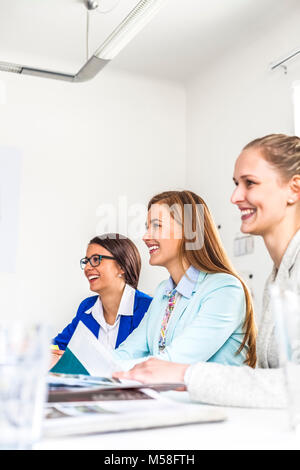 Lächelnde junge weibliche Mode Designer in Board Room Stockfoto