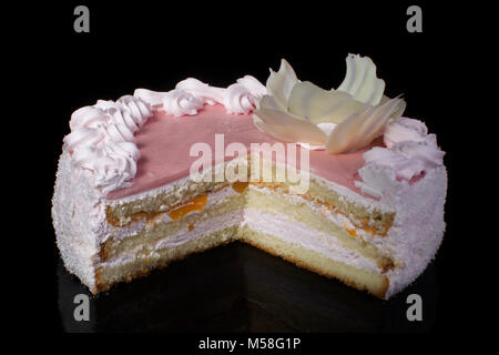 Scheibe des weißen Kuchen mit rosa Zuckerglasur auf schwarzem Hintergrund Stockfoto