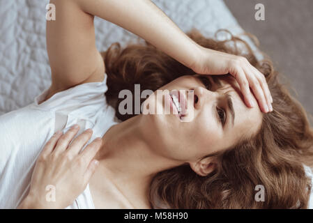 Frustrierte Frau mit schweren Kopfschmerzen Stockfoto