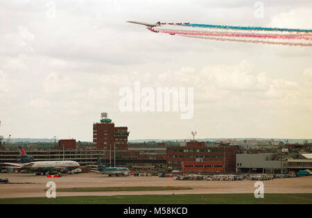 Einen British Airways Concorde führt die Royal Air Force Red Arrows Anzeige Squadron, wie Sie über London Heathrow Flughafen, der feiert sein 50 annniversary war Fliegen. Stockfoto