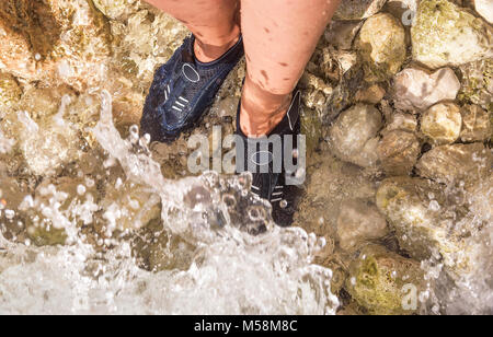 Spezielle Schuhe für Wanderungen auf die Steine im Meer. Stockfoto