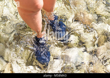 Spezielle Schuhe für Wanderungen auf die Steine im Meer. Stockfoto