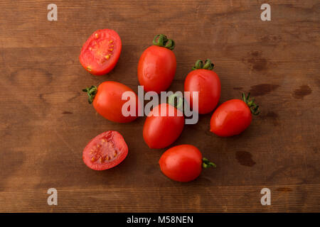 Blick von oben auf die Frische rote Baby Tomaten auf braunem Holz- Hintergrund Stockfoto