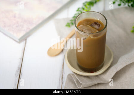 Immer noch leben - ein Glas mit Eiskaffee auf weissem Holztisch. Stockfoto