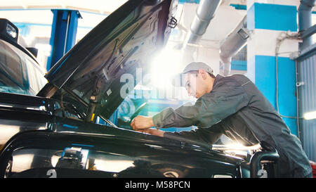 Mechaniker in car service - Reparatur im Motorraum für Luxus-SUV Stockfoto