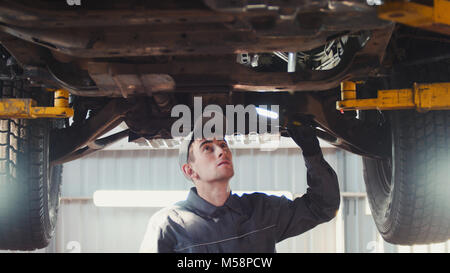 Auto Service - ein Mechaniker prüft die Aussetzung der SUV Stockfoto