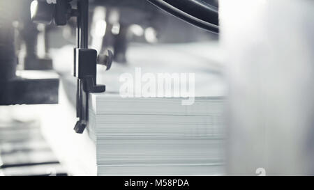 Gedruckte Blätter werden in der Druckmaschine serviert. Offset, CMYK Stockfoto