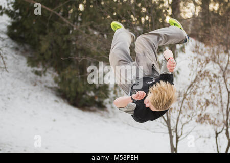 Backflip parkour im Winter Schnee Park springen - Free-run Training Stockfoto