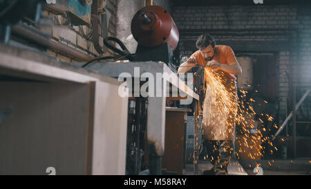 Schmiede in der Schmiede-Eisen Schärfen der Werkzeuge mit funkelt - metallwerkstatt Stockfoto