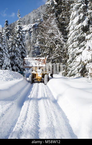 02/19/2018 Snow event. Ein Caterpillar 950 mit Gummibereifung artikuliert Lader Schneeräumen auf einem Berg Straße nördlich des Noxon, in Sanders County Montana. Stockfoto