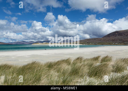 Die Spaziergänger am Strand von Seilebost, Isle of Harris, Äußere Hebriden, Schottland. Mit den Dünen von Luskentire Strand in der Ferne. Stockfoto