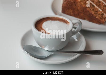 Eine Tasse Espresso Macchiato Kaffee und ein Stück Karottenkuchen Stockfoto