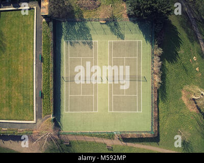 Luftaufnahme der Tennisplätze an einem sonnigen Tag, Netze im Schatten sichtbar Stockfoto