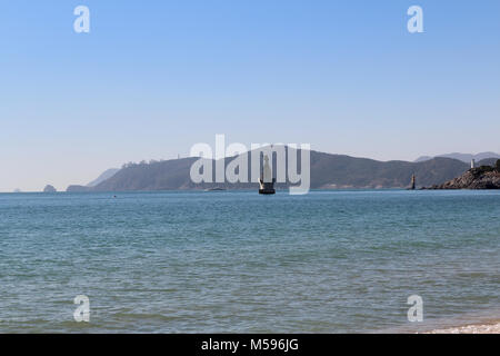 Blick auf Haeundae Meer in sonniger Tag mit dem Berg und Leuchtturm, Busan, Südkorea Stockfoto