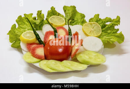 Salat auf einen Teller mit Tomaten Kohlblatt geschnittene Karotten Gurken und Zitronen mit grünem Chili. Stockfoto