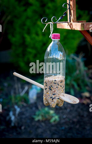 Hausgemachte Bird Feeder hängen von einem Vogel Tabelle, durch ein Schüler aus einer Getränkeflasche gebaut, ein Löffel aus Holz und einer Länge der Zeichenfolge Stockfoto