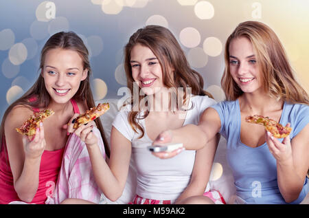 Glückliche Freunde Pizza essen und vor dem Fernseher zu Hause Stockfoto