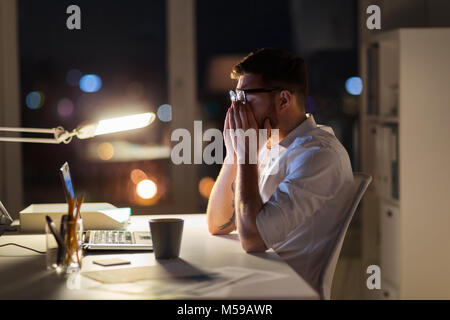 Müde Geschäftsmann mit Laptop in der Nacht Büro Stockfoto